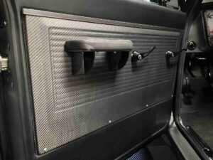 A close up of the door handle on an airplane.